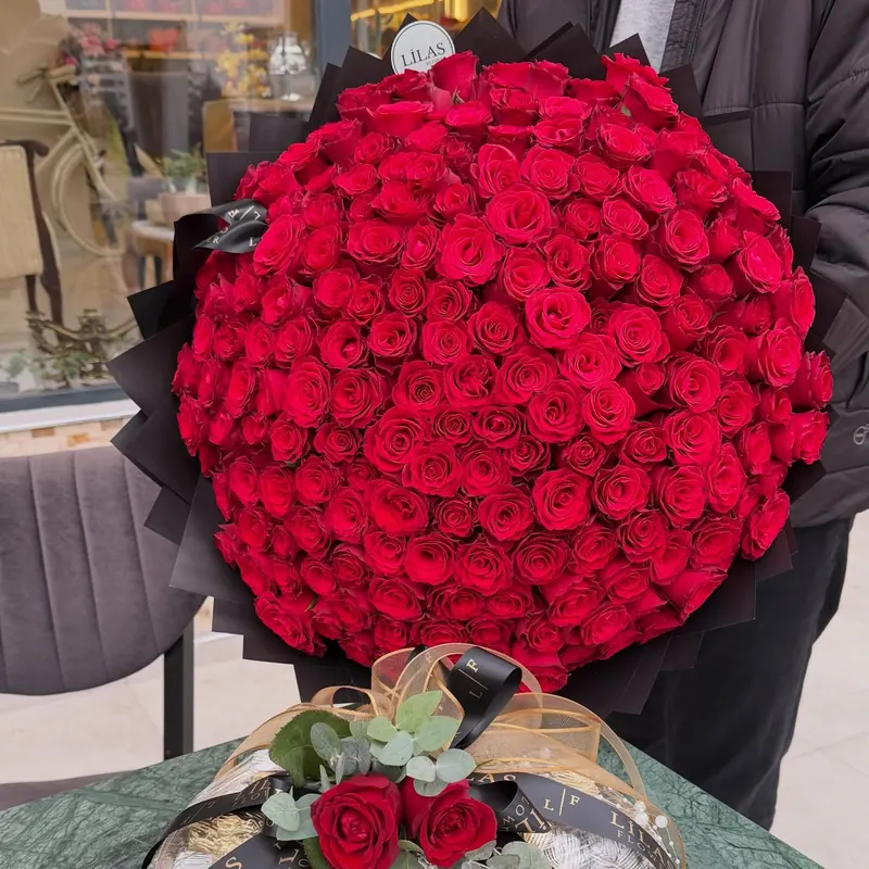 Siyah ambalajlı büyük kırmızı gül buketi, Lilas Flower dükkânının önünde